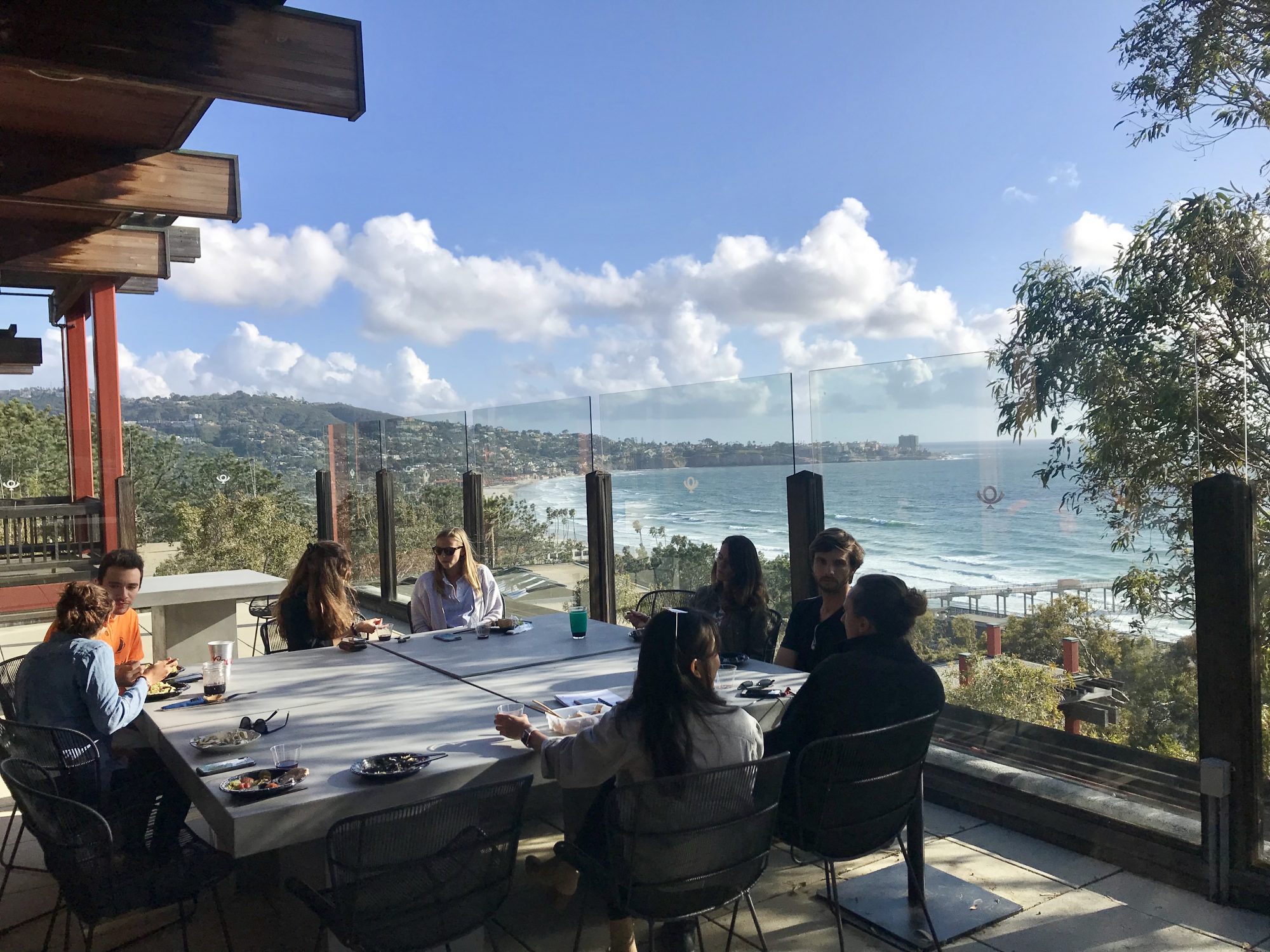 CSP students eat at table overlooking Pacific Ocean.
